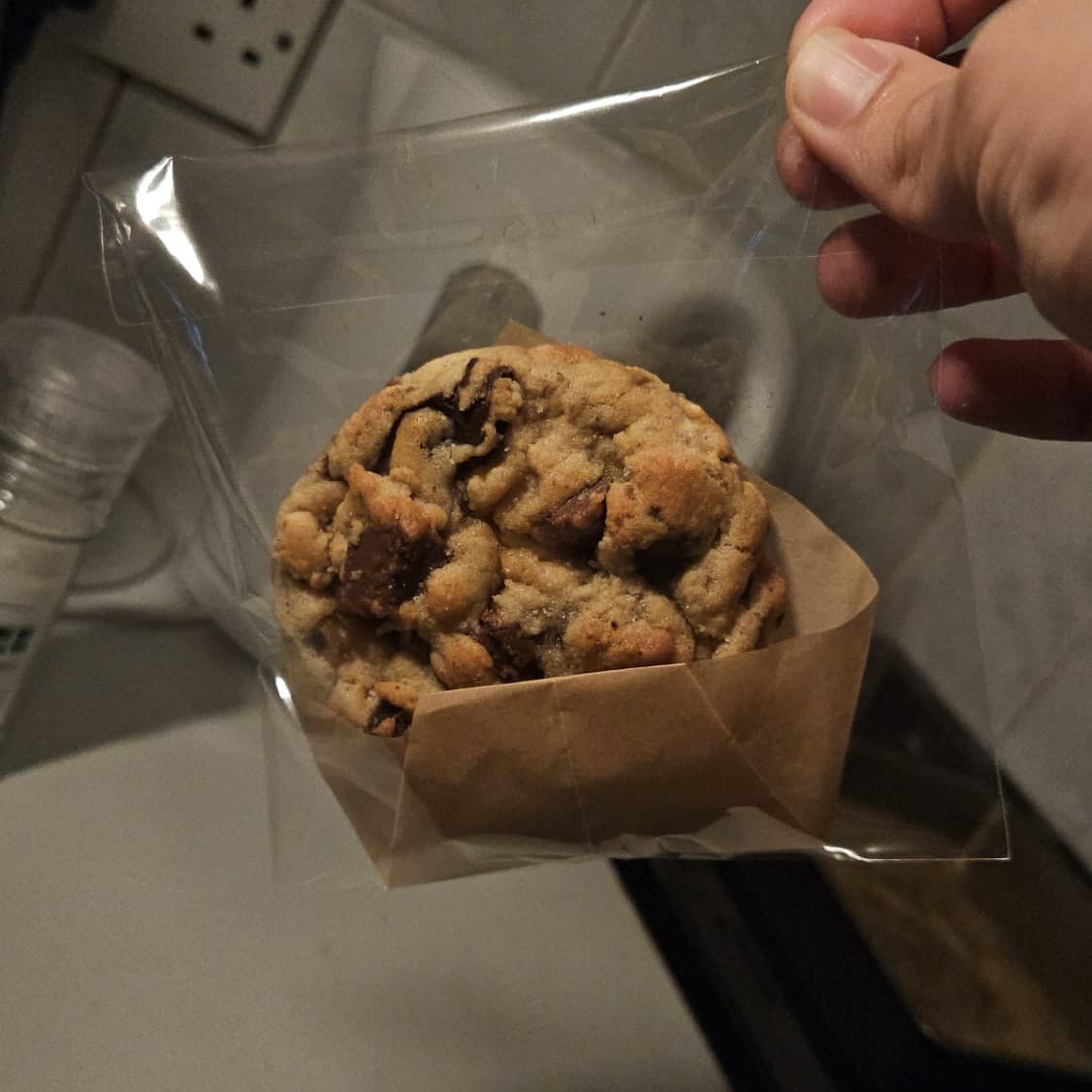 A warm chocolate-chunk cookie, wrapped in parchment.